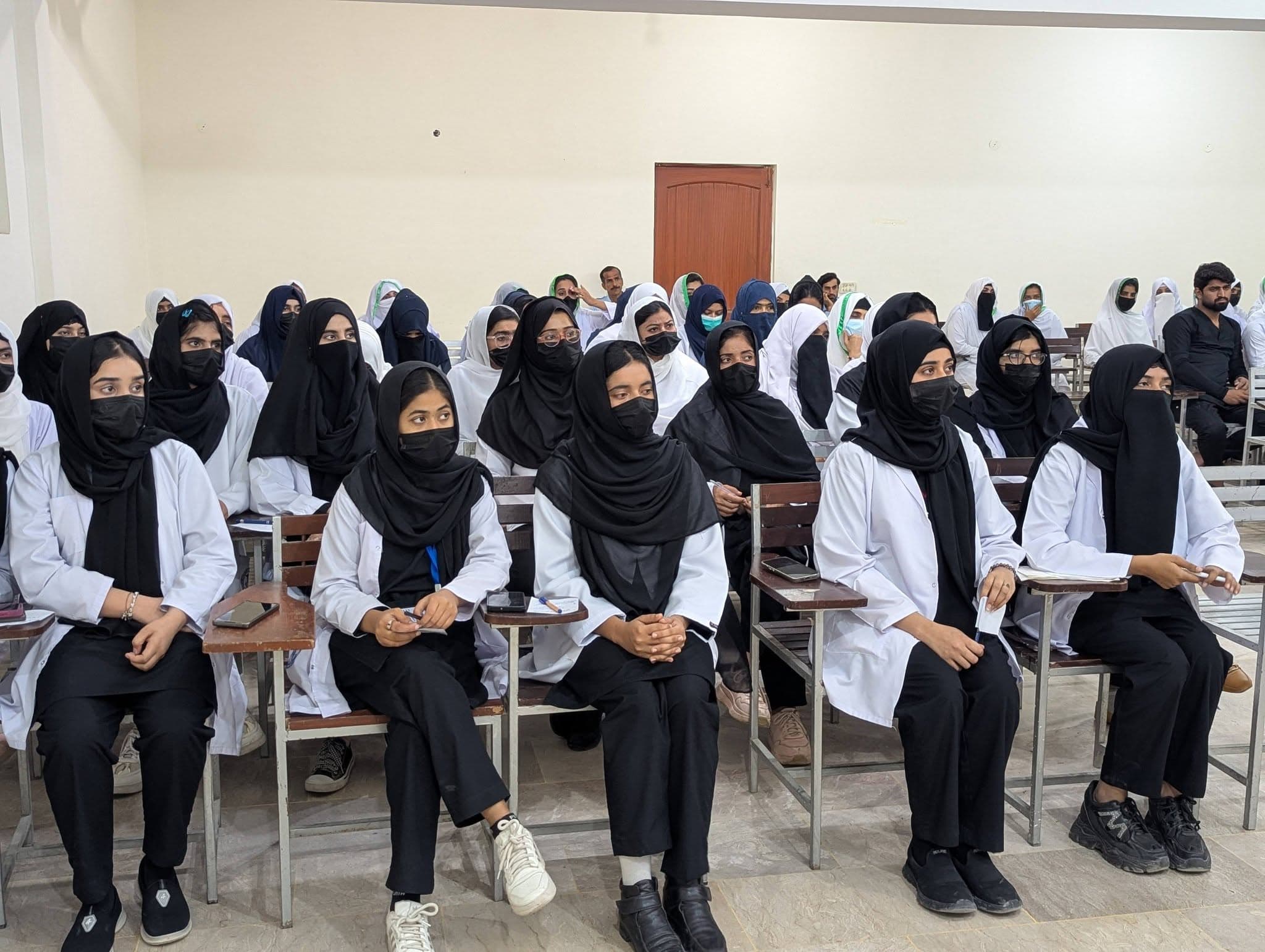 RIAHS students in white coats in a classroom